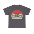 Gray T-shirt featuring a retro sunset circle graphic and bold white text reading RESTING BEACH FACE.