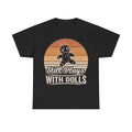 Black T-shirt with retro sunset graphic featuring a stitched voodoo doll and the phrase Still Plays With Dolls