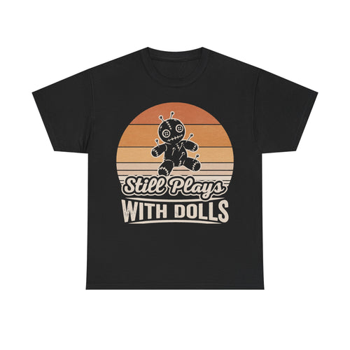 Black T-shirt with retro sunset graphic featuring a stitched voodoo doll and the phrase Still Plays With Dolls