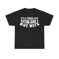 Black T-shirt with bold distressed white text IT'S A TOUGH LIFE HAVING SUCH A HOT WIFE