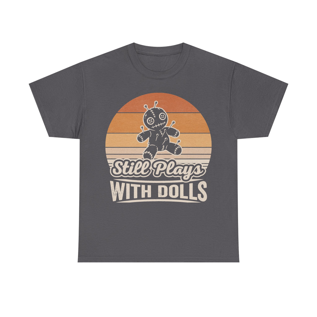 T-shirt with Still Plays With Dolls graphic on dark gray, featuring a retro sunset background and a stitched voodoo doll illustration.