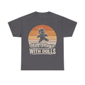 T-shirt with Still Plays With Dolls graphic on dark gray, featuring a retro sunset background and a stitched voodoo doll illustration.