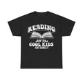 Black T‑shirt featuring a vintage white open-book graphic and the text Reading All The Cool Kids Are Doing It in bold typography.